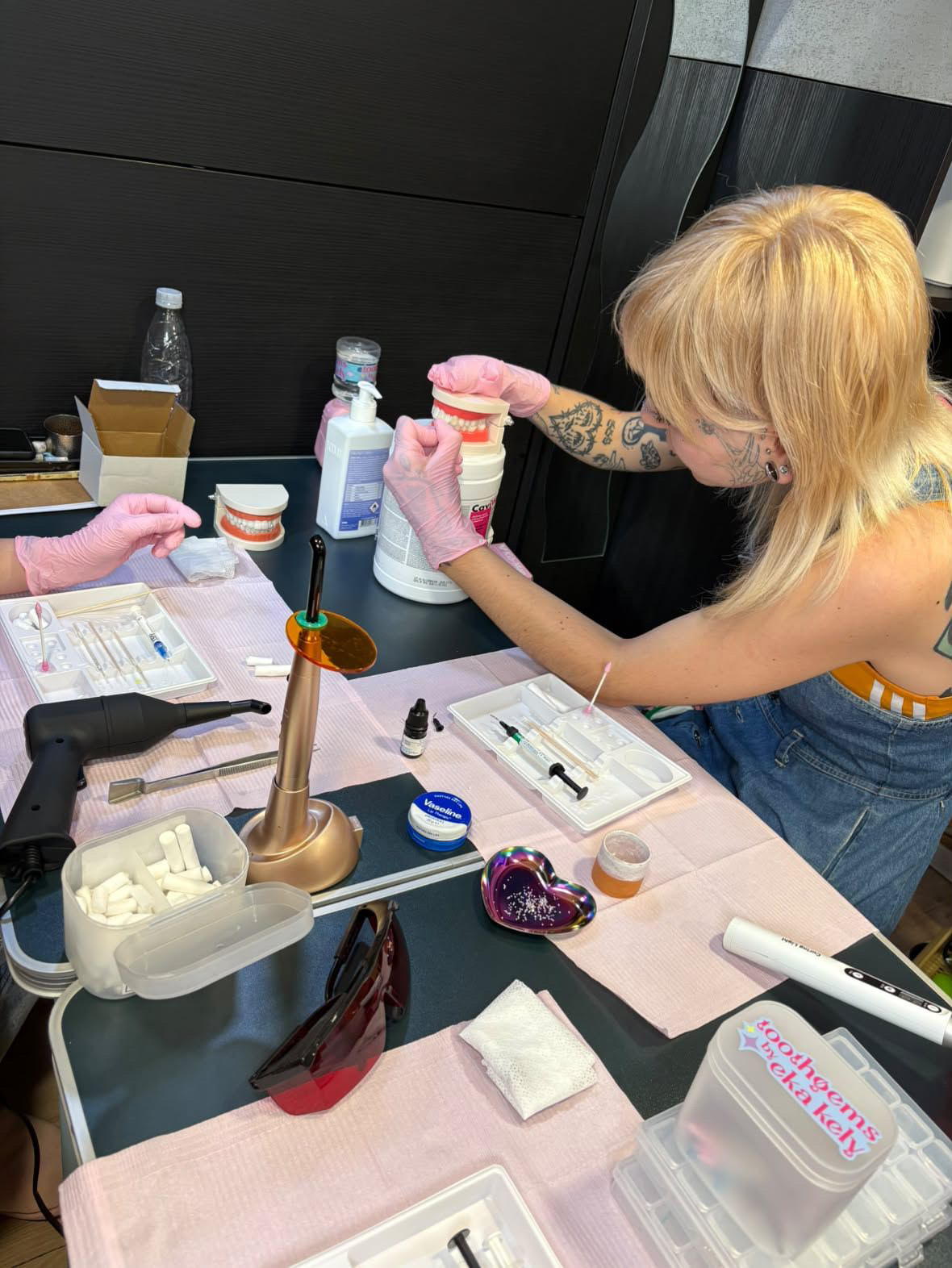 Hands-on tooth gem application practice on a model during the course